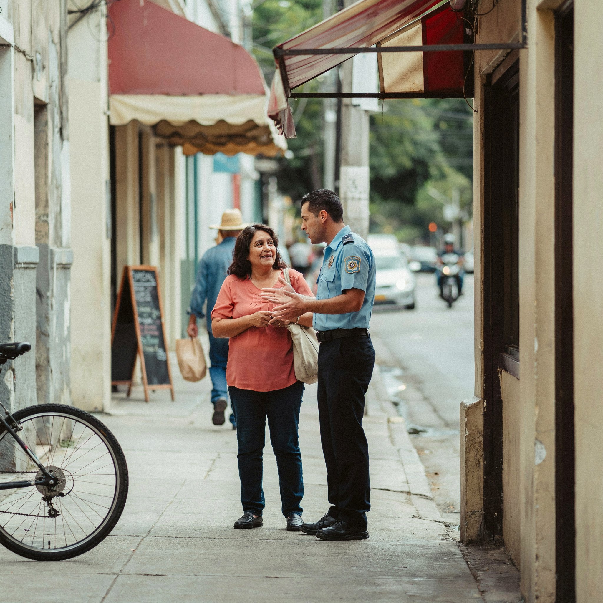 A police officer in conversation with a community member on a city street